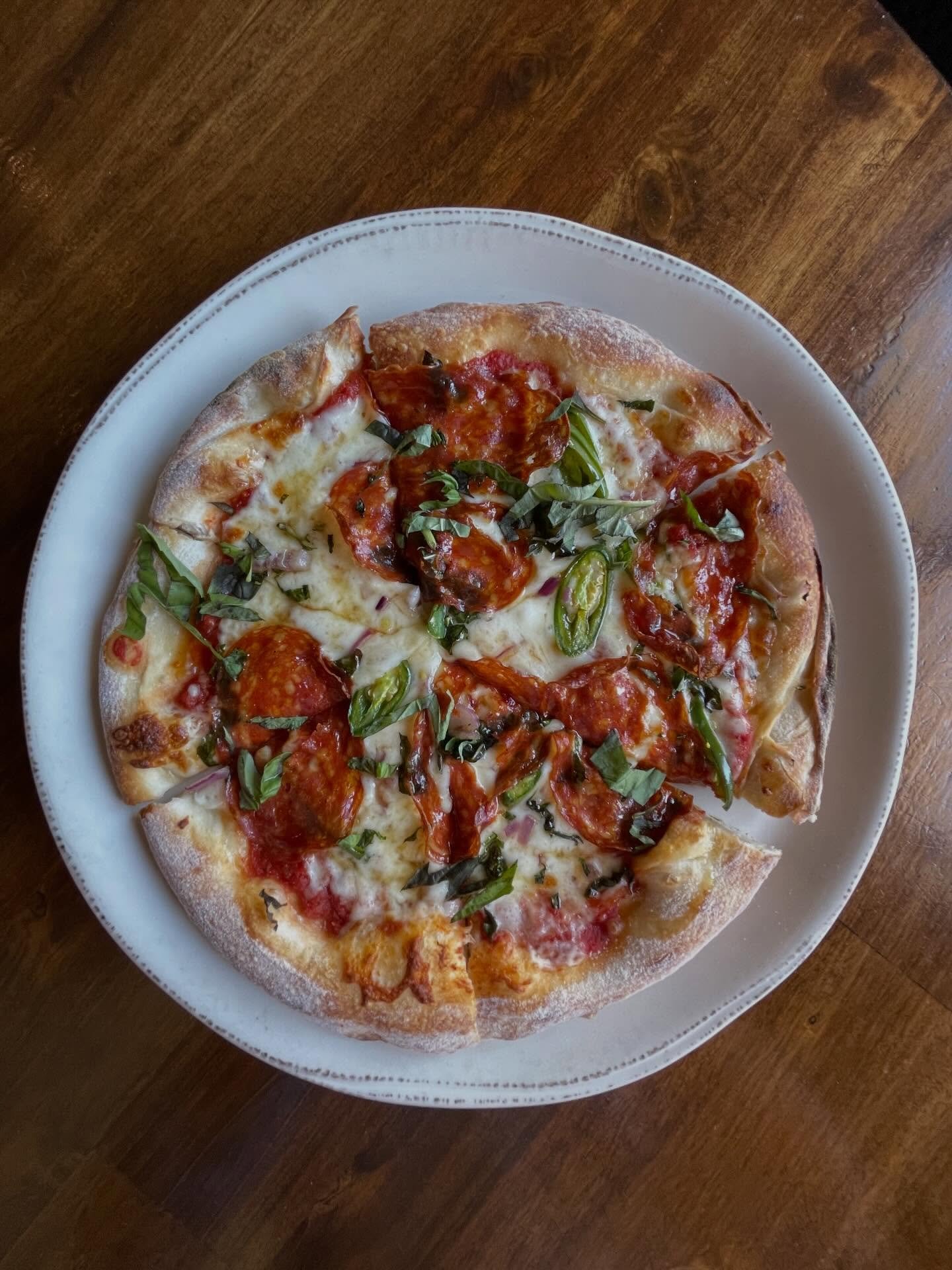 Wood-fired pepperoni pizza with fresh basil