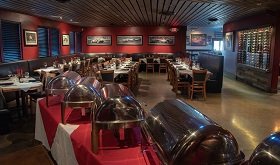 Turn 12 dining room with red walls and framed racing artwork
